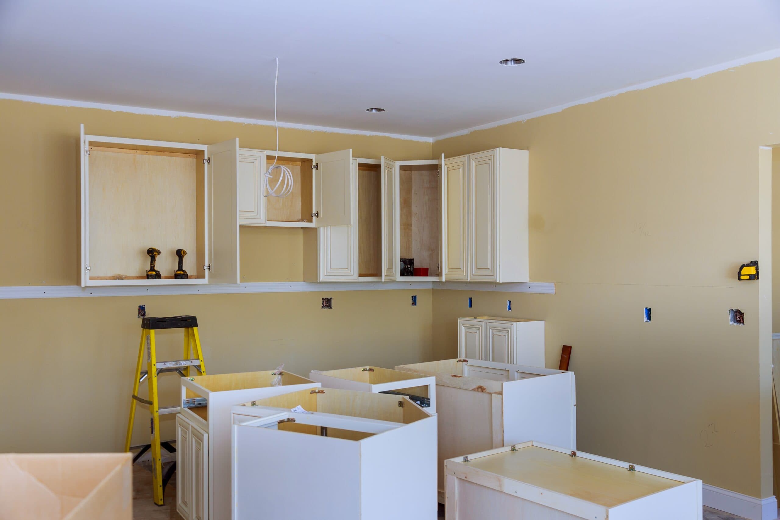Custom kitchen cabinets in various stages of installation Custom kitchen cabinets in various stages of installation base for island in center